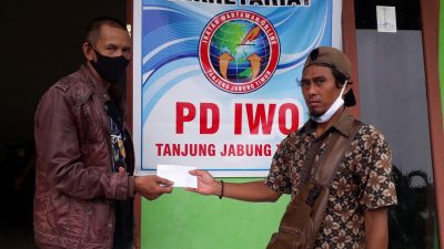 Ketua IWO Tanjabtim, Akhmad Sulian Firdaus menyerahkan uang hasil penggalangan dana kepada perwakilan keluarga almarhum Azman, Selasa (11/05/21). SELOKO.ID/Istimewa.