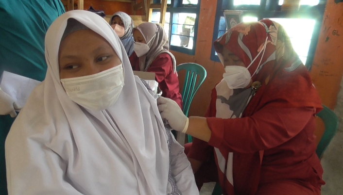 Salah seorang santri mengikuti vaksinasi Covid-19 yang digelar alumni Akabri 99 di Pondok Pesantren Nurul Iman, Kecamatan Mestong, Kabupaten Muaro Jambi. (foto: istimewa)