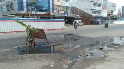 Warga di Kelurahan Talang Banjar, Kecamatan Jambi Timur, Kota Jambi menutupi jalan rusak yang berlobang dengan menanam pisang. Warga kesal karna jalan tak kunjung di perbaiki. (foto: istimewa)