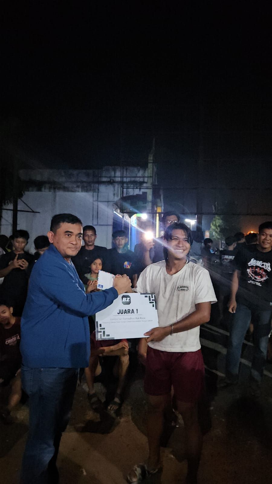 Kapolres Muaro Jambi, AKBP Heri Supriawan saat memberikan hadiah kepada pemenang lomba balap lari di Sungai Gelam.