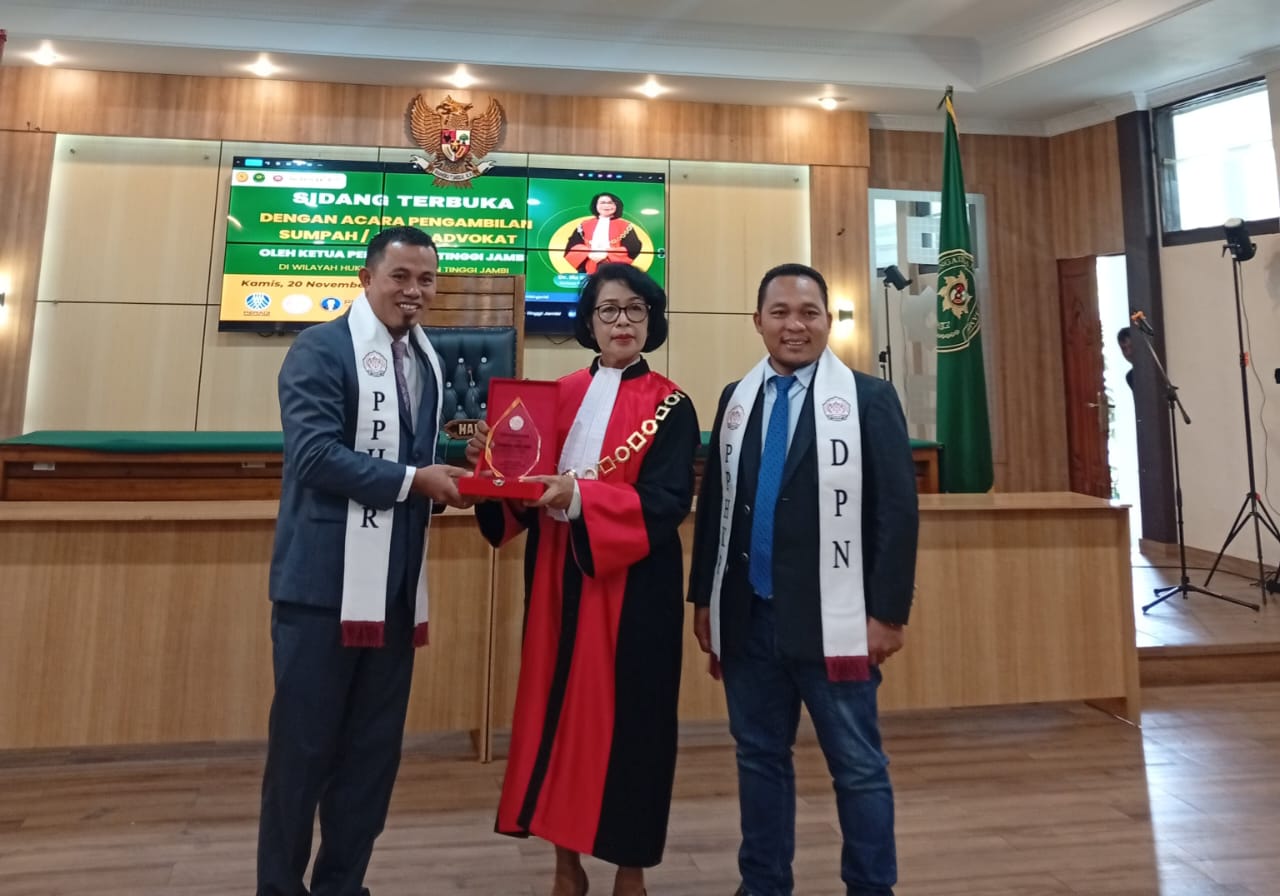 Pemberian plakat kepada Ketua Pengadilan Tinggi Jambi oleh organisasi advokat Perkumpulan Penasehat Hukum Keadilan Rakyat (PPHKR) di momen sidang terbuka pengambilan sumpah advokat di Pengadilan Tinggi Jambi, Kamis 20 November 2025.